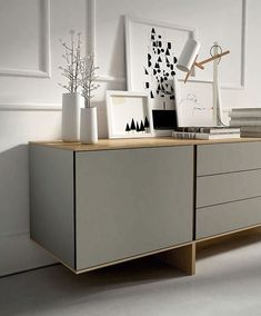 a white dresser topped with vases and pictures