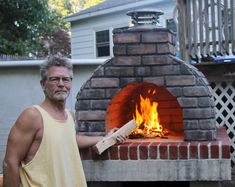 a man standing in front of a brick oven with the words large oven on it