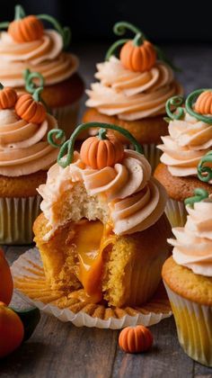 several cupcakes with frosting and pumpkin decorations