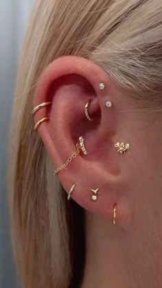 a woman's ear with three different types of piercings