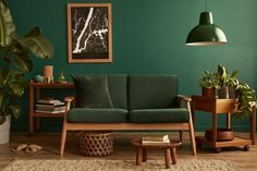 a living room with green walls and wooden furniture, including a small couch in the middle