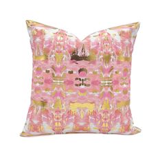 a pink and gold pillow with an abstract design on the front, along with a white background