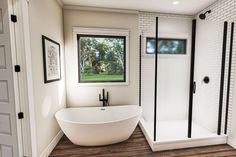 a white bath tub sitting inside of a bathroom next to a walk - in shower