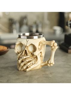 a skull shaped coffee mug sitting on top of a counter