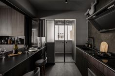 a kitchen with black counter tops and dark wood cabinetry, along with an island in the middle