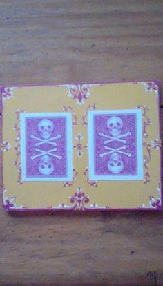 a yellow and pink box with two skulls on the inside, sitting on top of a wooden table