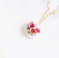 a white necklace with pink flowers on it