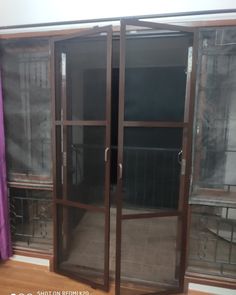 an empty room with glass doors and purple curtains on the window sill in front of it