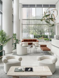 a living room filled with lots of furniture and large windows in the back drop off wall