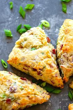 several scones on a table with green onions and other food items around the edges