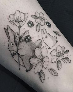 a black and white photo of a tattoo with flowers on the side of someone's leg