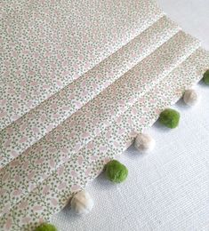 the wall paper is lined up with green pom poms on top of it