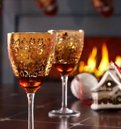 two wine glasses sitting on top of a table next to a christmas ornament