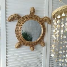 a mirror hanging on the side of a wall next to a window covered in shells