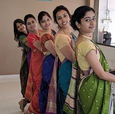 several women in sari are standing next to each other and posing for the camera