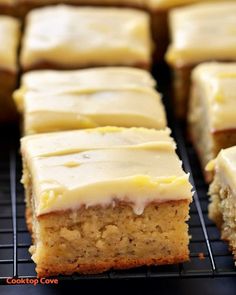 there are many pieces of cake on the cooling rack and one is frosted with icing