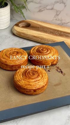 three croissants sitting on top of a cookie sheet