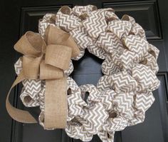 a wreath with burlocks and bows hanging on the front door