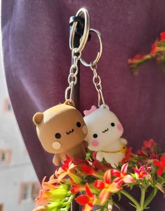 two key chains are attached to the back of a person's body, with flowers in front of them