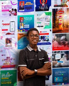 a young man standing in front of a wall covered with advertisements and advertising materials,