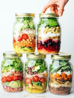 several mason jars filled with different types of salads and vegetables, each containing various ingredients