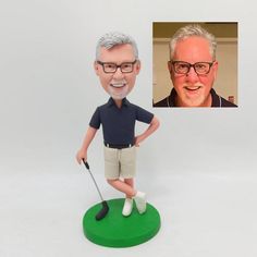 a bobble head with a man holding a golf club and smiling at the camera