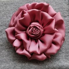 a large pink flower sitting on top of a gray blanket