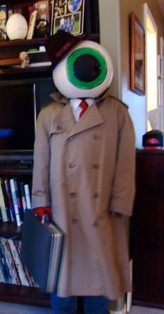 a man in a trench coat with an eyeball on his head and holding a briefcase