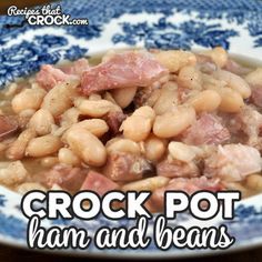 a blue and white plate topped with ham and beans