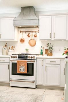 a stove top oven sitting inside of a kitchen next to white cabinets and counter tops