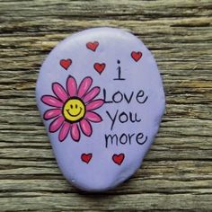 i love you more painted on a rock with hearts and a smiley face in the center