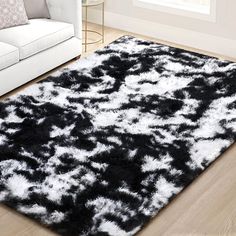 a black and white area rug on the floor in a living room with a couch