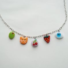 the necklace has five different charms attached to it's chain and is decorated with fruit