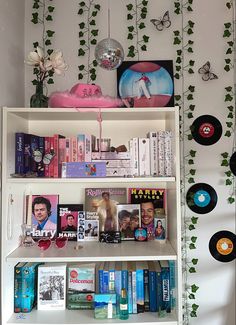 a book shelf filled with lots of books and vinyl record's on top of it