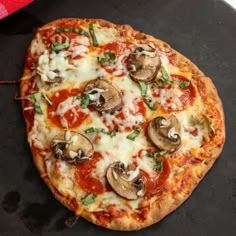 a pizza sitting on top of a pan covered in cheese and mushrooms