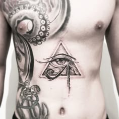 a man with an all seeing eye tattoo on his chest