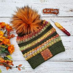 a knitted hat with an orange fur pom