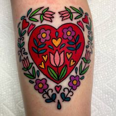 a heart tattoo with flowers and hearts on it