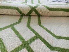 a green and white blanket sitting on top of a bed