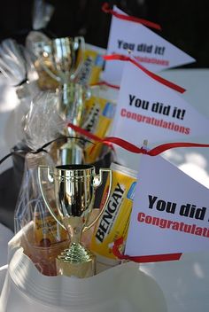 there are many signs on the table that say you did it congratulations and have trophies in front of them