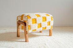 a yellow and white bench sitting on top of a rug