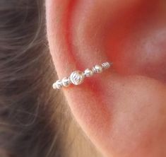 a woman's ear with three balls attached to it