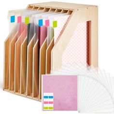 several folders and papers are stacked in a wooden box with different colors on them