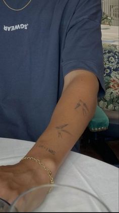 a man with a tattoo on his arm sitting at a table