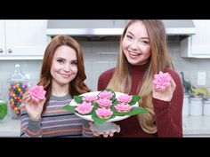 two women holding pink flowers in their hands