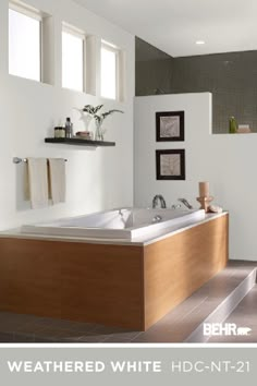 a bathroom with two sinks and a bathtub in it's center, surrounded by tiled walls