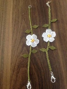 two crocheted flowers are attached to chains