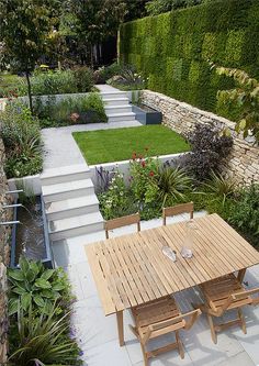 a wooden table sitting in the middle of a garden