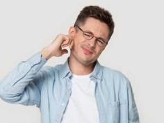 a man wearing glasses is holding his head in one hand and looking at the other