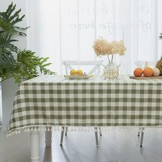 the table is covered with a checkered cloth and has fruit on it, along with pineapples